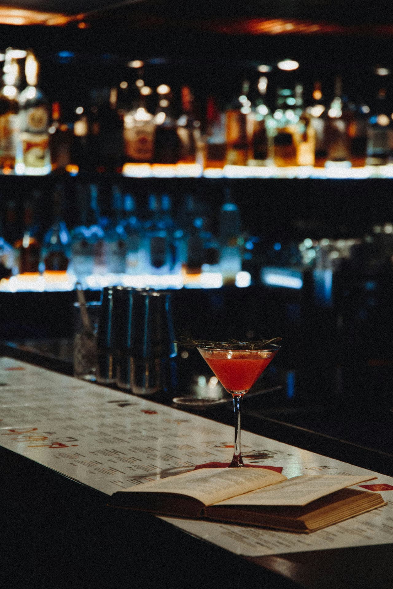 A cocktail on the bar counter, drink menu in a digital menu